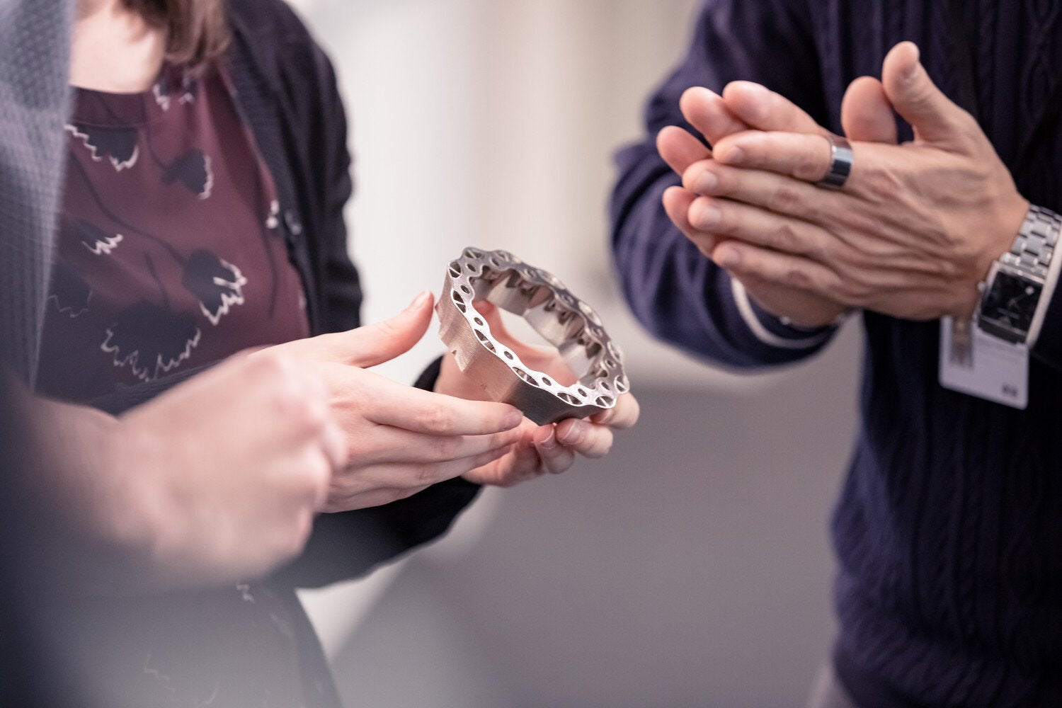 Woman holding a metal part.