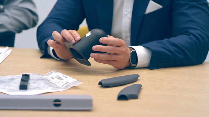 Homme tenant une pièce en polymère.